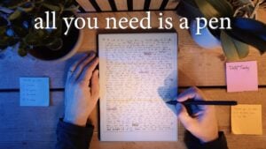 A person writing with a pen to foster self-reflection and clarity