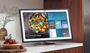 Fire TV interface on the 21.5-inch display, streaming YouTube while adaptive brightness keeps the screen comfortable.