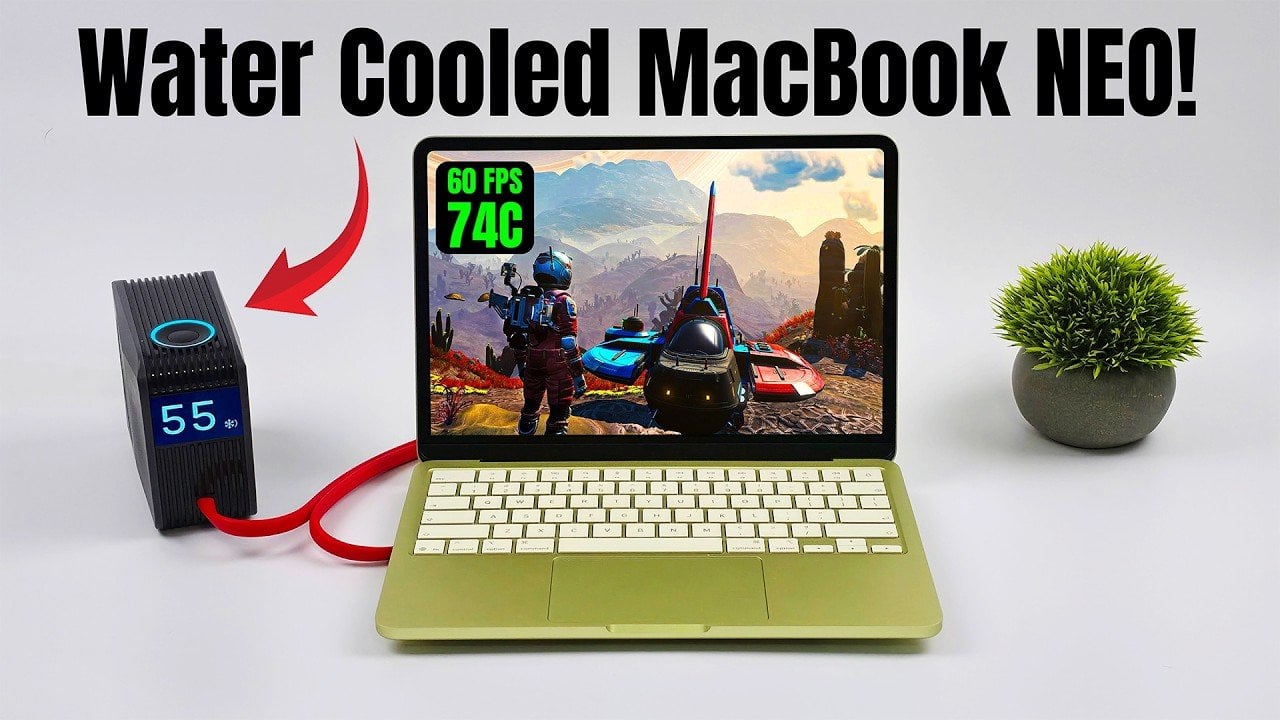 MacBook Neo on a desk with external liquid cooling attached, showing tubing and a compact radiator module.