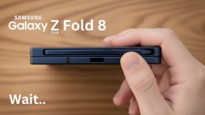 Hand holding a compact clamshell foldable with a slimmer hinge area representing the Galaxy Z Flip 8 design push.