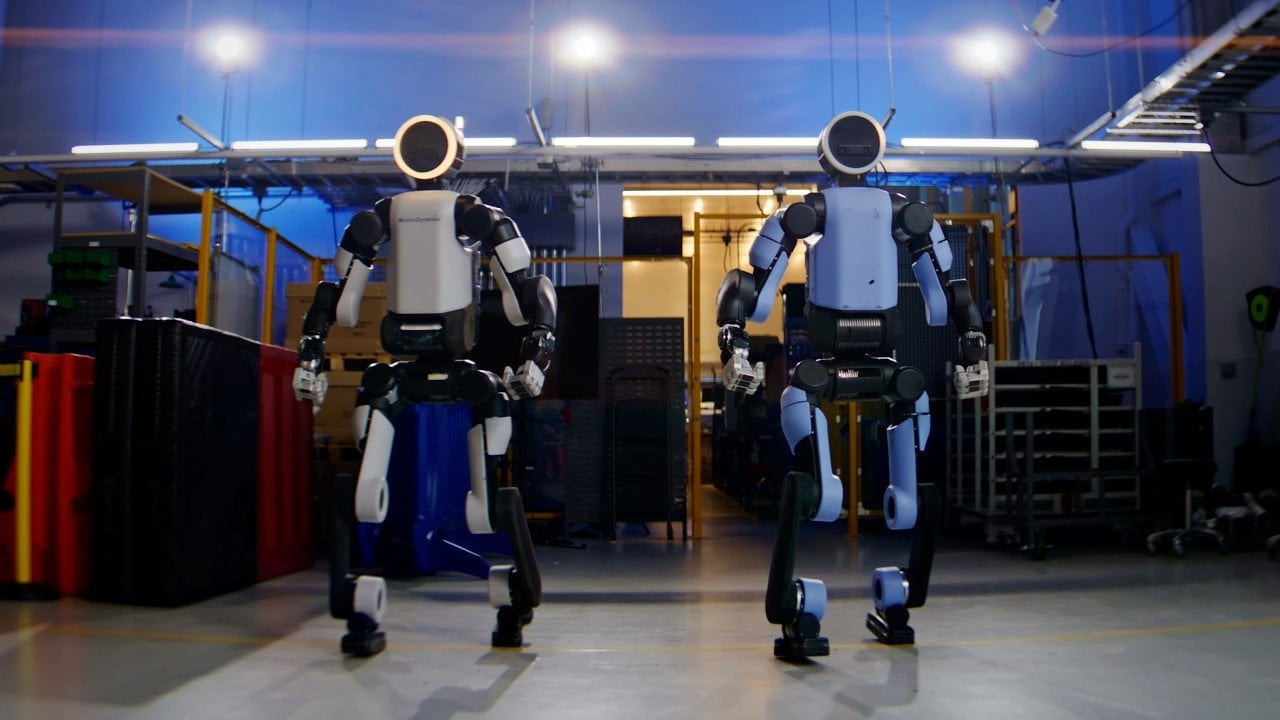 Atlas humanoid robot lifting a 100-pound refrigerator using full-body motion.