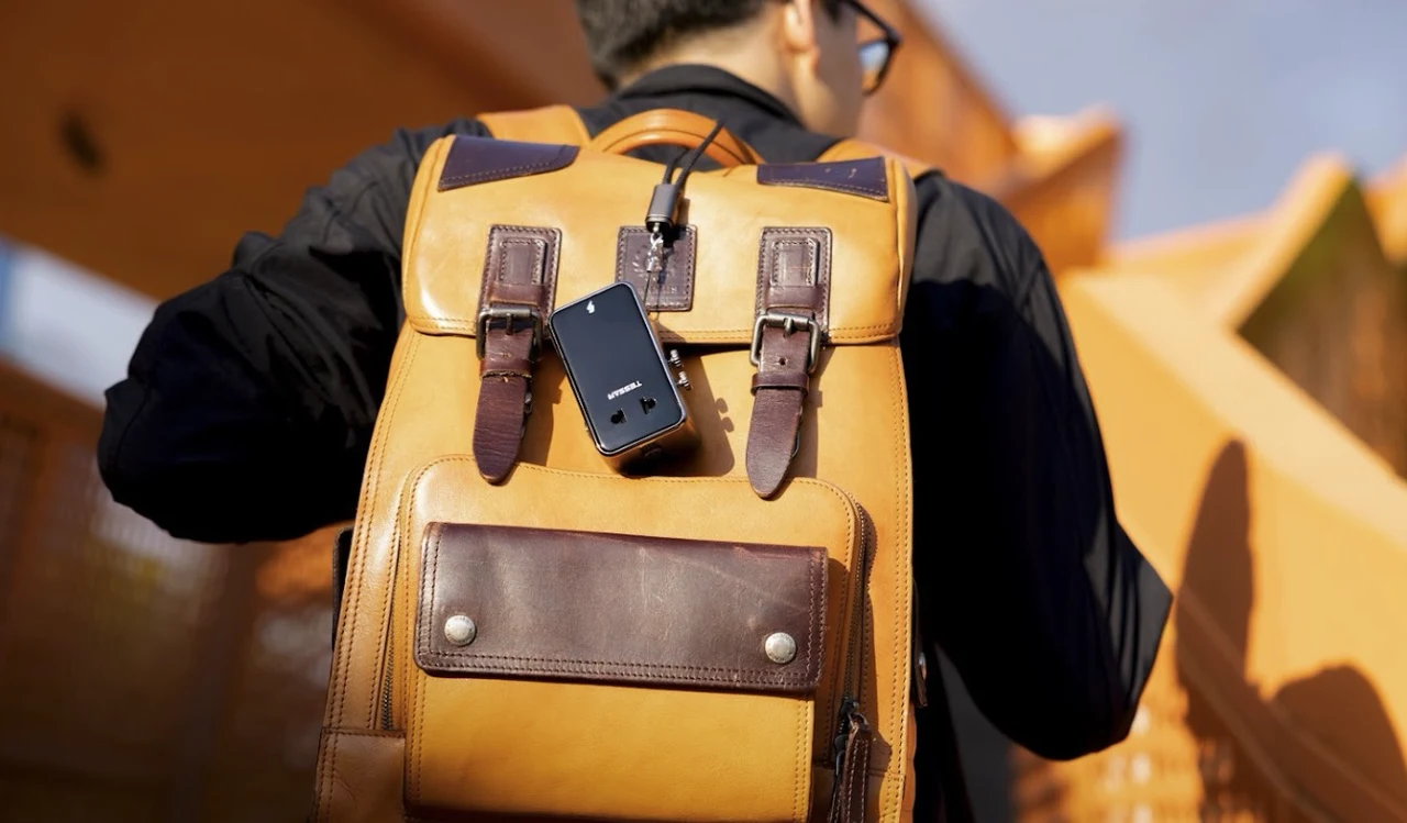 TESSAN AERO 70 travel adapter clipped to a backpack while sightseeing