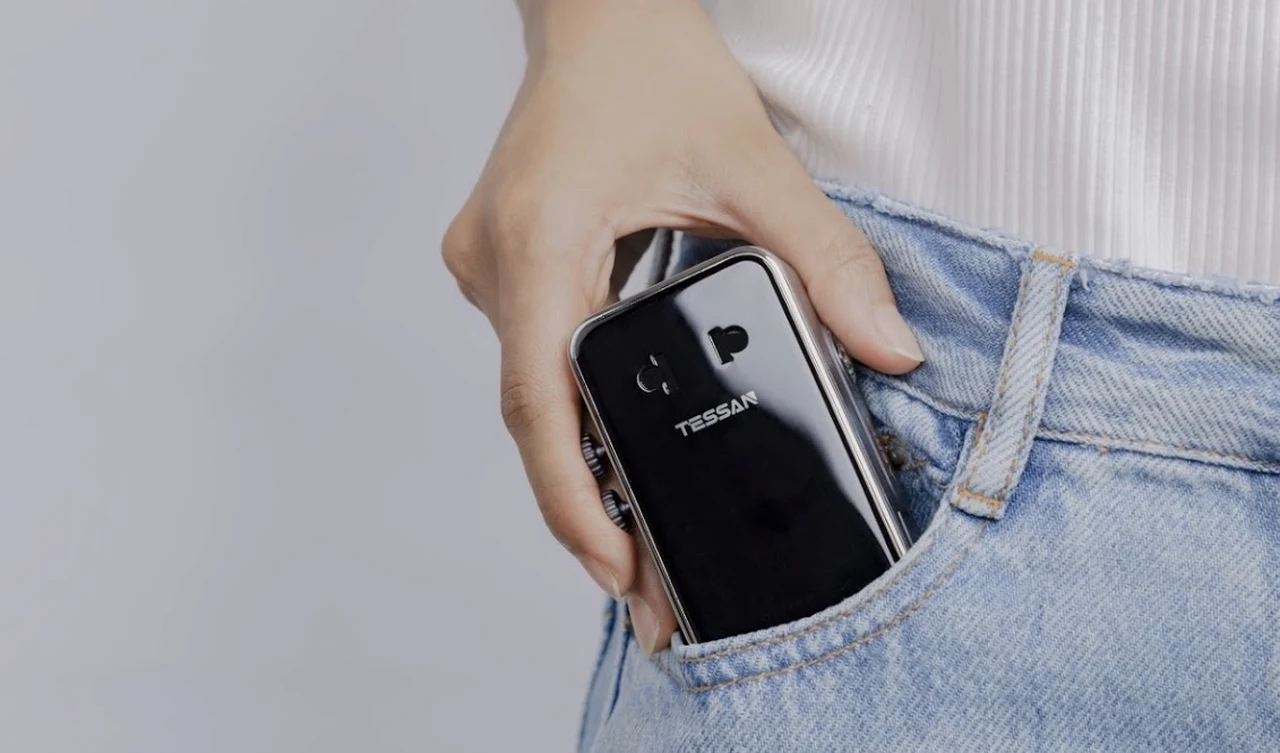 Traveller slipping the TESSAN AERO 70 travel adapter into a jeans pocket