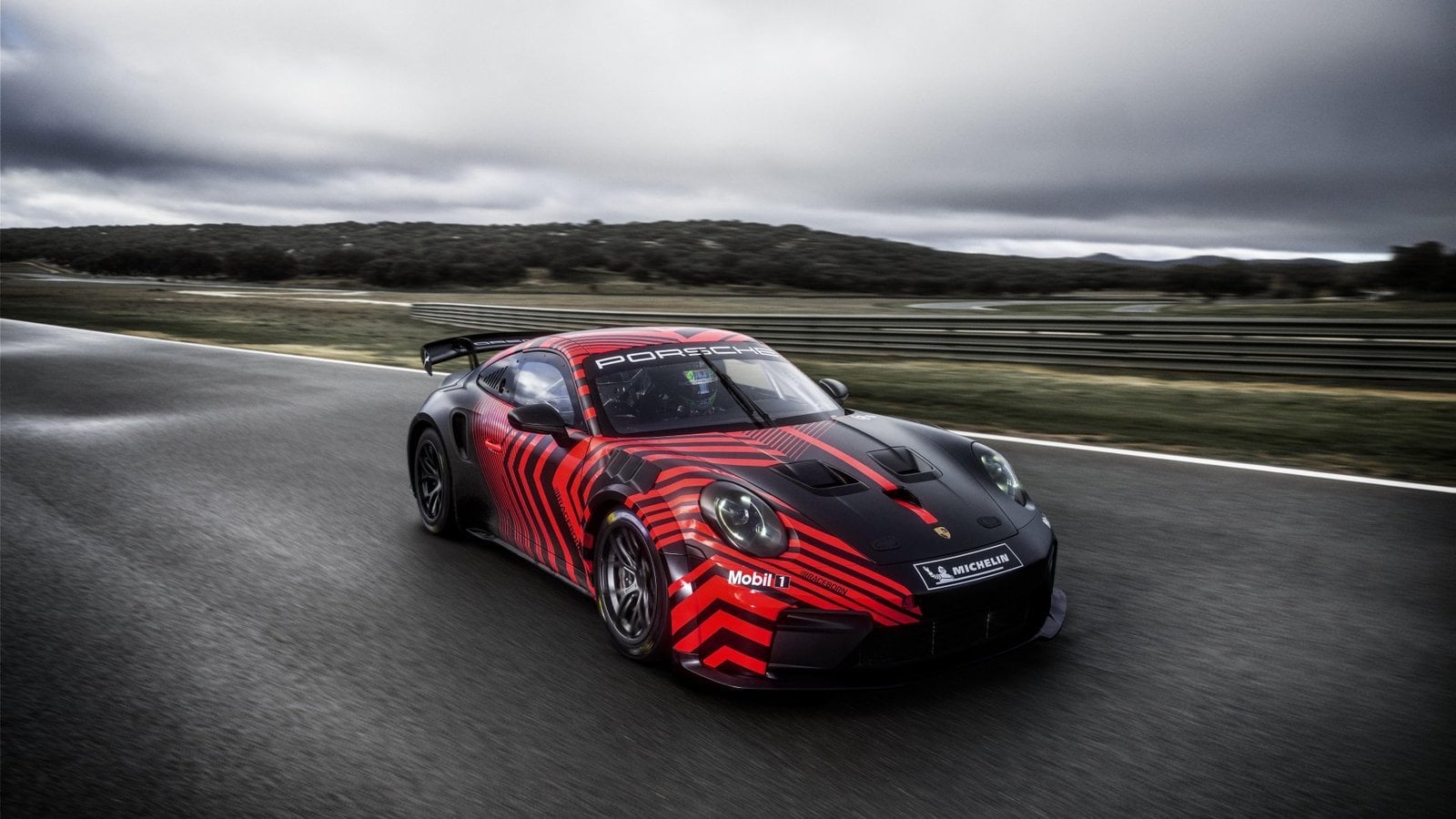Porsche 911 GT4 R driving through a corner during a motorsport event