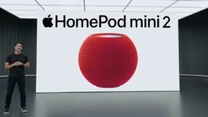 White HomePod mini 2 sitting on a wooden desk