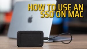 An external SSD connected to a Mac laptop via a Thunderbolt cable.