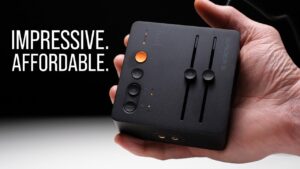 The Fosi C3 gaming DAC sitting on a desk next to a gaming headset.