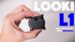 A close-up of the Looki L1 wearable camera resting in the palm of a hand.