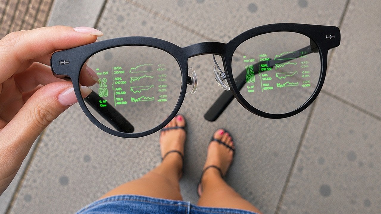 A pair of MemoMind One smart glasses resting on a table.