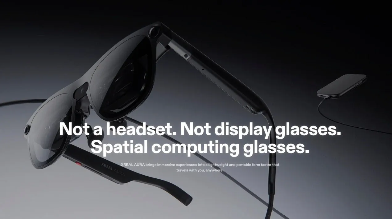 A person wearing the XREAL Aura glasses while working on a laptop.
