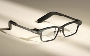 Person wearing MemoMind One smart glasses while working at a desk.