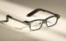 Person wearing MemoMind One smart glasses while working at a desk.