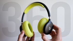 Black Beats 360 over-ear headphones resting on a wooden desk.