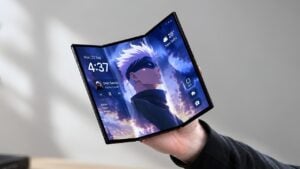 A person holding a thin tri-fold smartphone in their hand