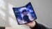 A person holding a thin tri-fold smartphone in their hand