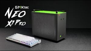 The GMKtec NEO X1 Pro sitting on a desk highlighting its gray and green color scheme.