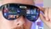 A person wearing the Unseen Reality URXR1 glasses while typing on a laptop.