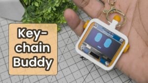 A completed tiny ESP32 OLED keychain displaying graphics.