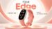 The Fitbit Edge fitness tracker and its packaging resting on a desk.