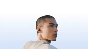Profile view of a person wearing the open-ear Samsung earbuds.