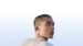 Profile view of a person wearing the open-ear Samsung earbuds.